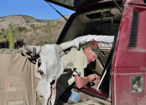 Morning at the canyon camp…Ned gets his workout tightening the alternator belt, while our new mascot looks on…
