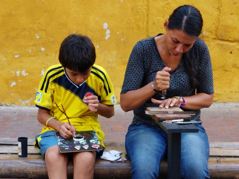 A resourceful mother and son team.  Mom was cutting little soccer ornaments out of wood, while the youngster painted them in bright colors.