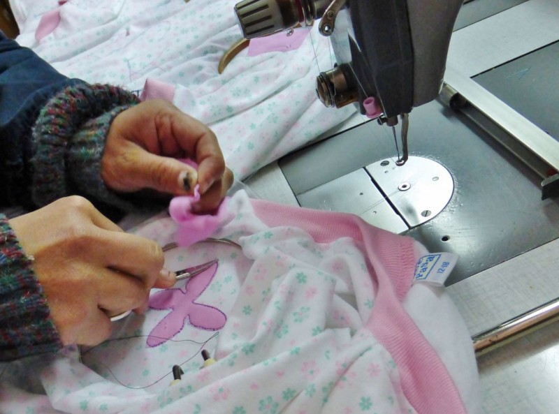 The hand work going on was amazing.  After the pink star-like thingy was sewn onto the garment by a machine, a lady hand cut away the excess material with manicure succors, one after the other, all day.